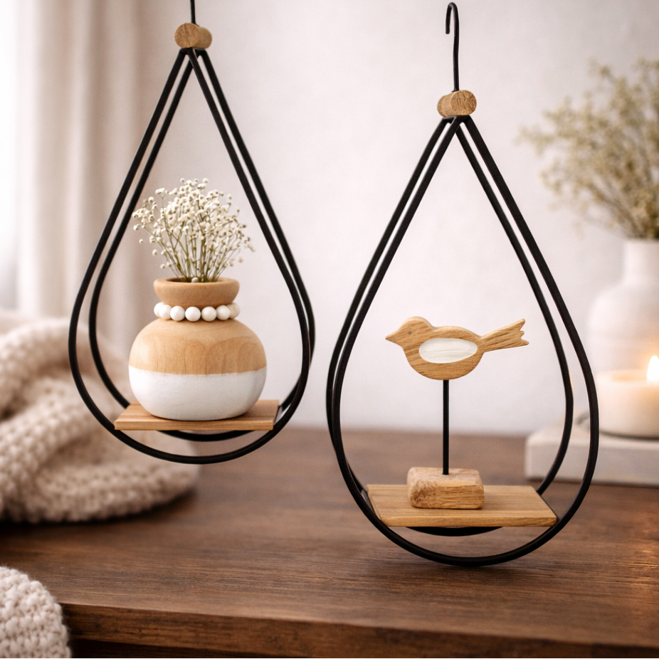 Decorative hanging shelves with plants and a bird figurine on a wooden surface.